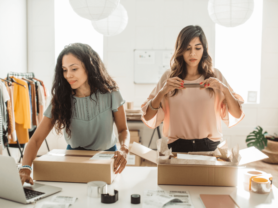 Women co-founders preparing labeled boxes for shipping, showcasing their business's GS1 certification for retail standards.