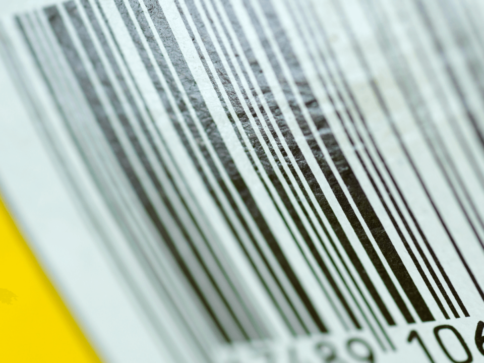 Detailed GS1 US barcode on a yellow background, showing a sequence of digits for product identification.