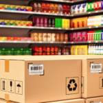 Stacked cardboard boxes with GS1 barcodes in a retail store aisle filled with colorful packaged products.