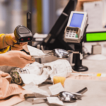 Retail worker scanning receipts at a checkout counter, symbolizing inventory management and product tracking.