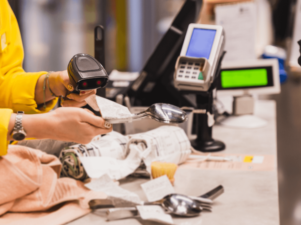 Retail worker scanning receipts at a checkout counter, symbolizing inventory management and product tracking.